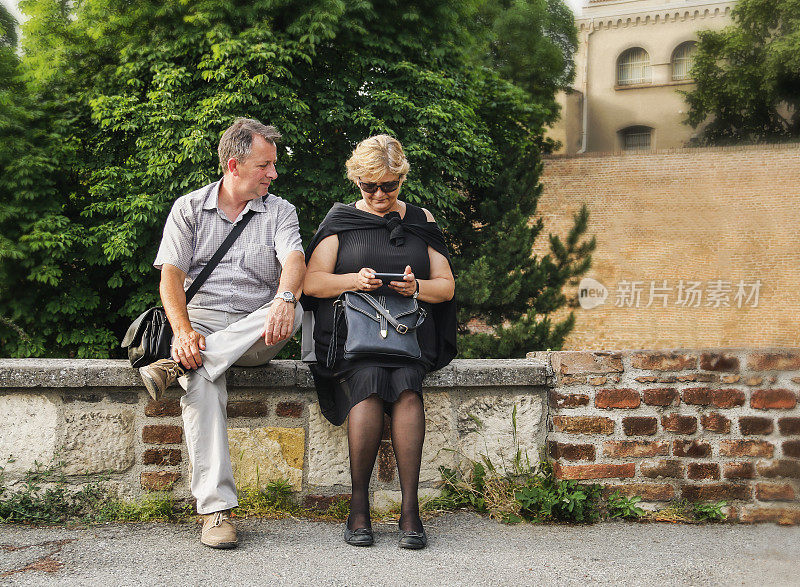 一对中年夫妇在看智能手机。