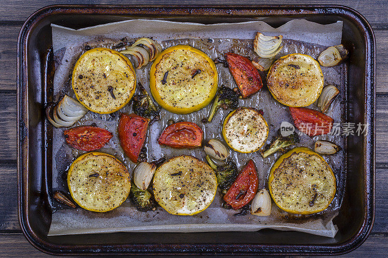 西葫芦，西红柿，花椰菜和洋葱在烤箱里烤。俯视图