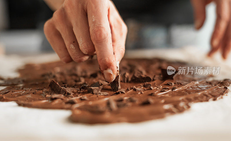 专业的糖果师用融化的巧克力制作美味的蛋糕