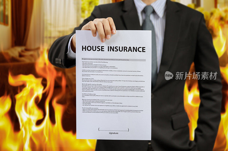 商人显示房屋保险单与火灾