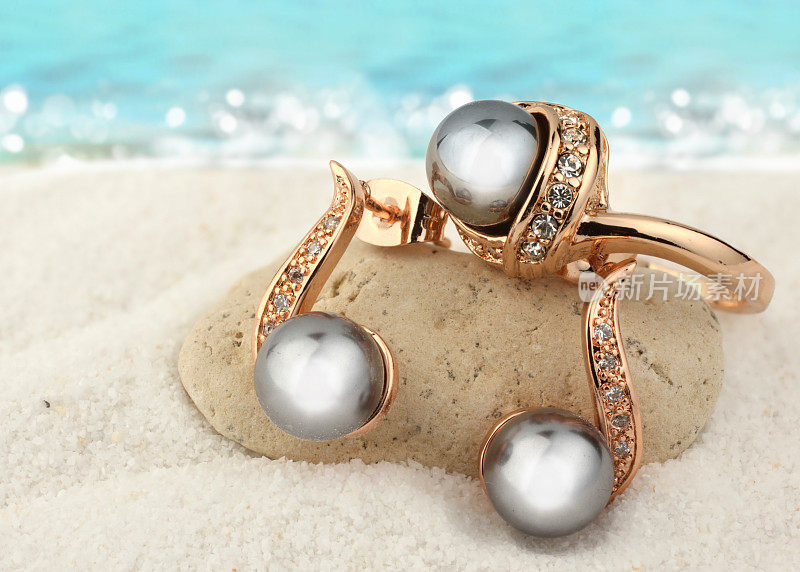 珠宝与黑珍珠在沙滩上的背景
