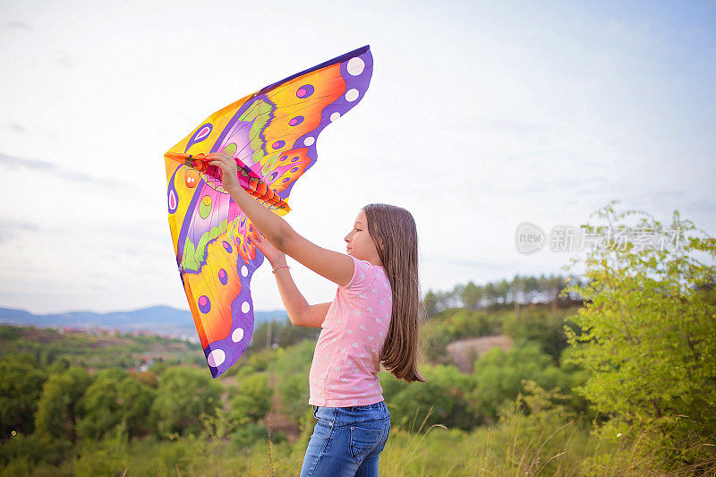 女孩拿着风筝跑
