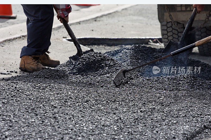 在公路维修现场铺热沥青