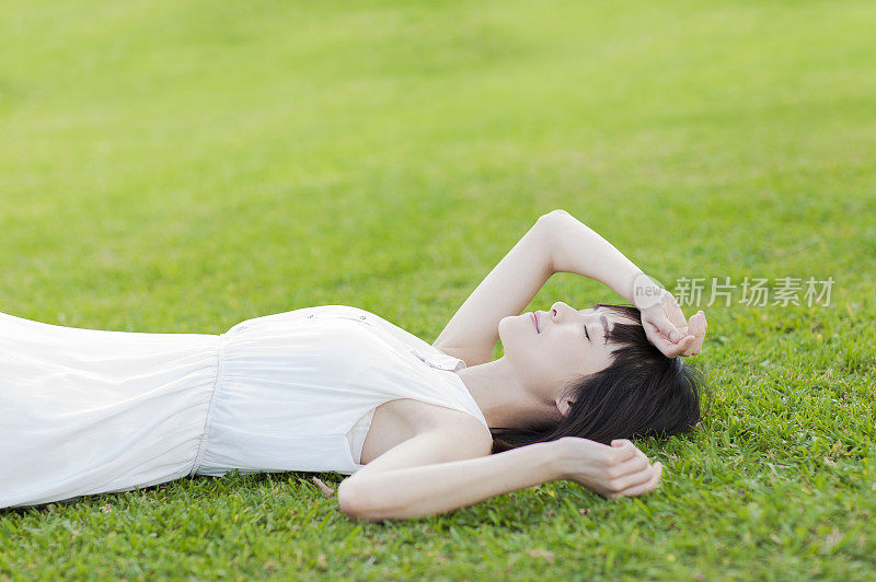年轻女人躺在草地上睡觉