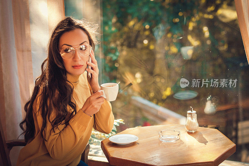 在家喝茶或喝咖啡的女人。窗外景色