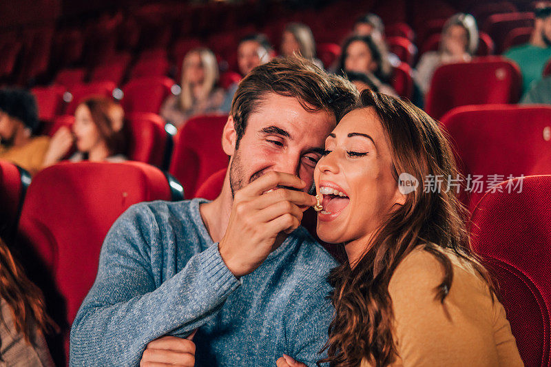 一对夫妇在电影院吃爆米花