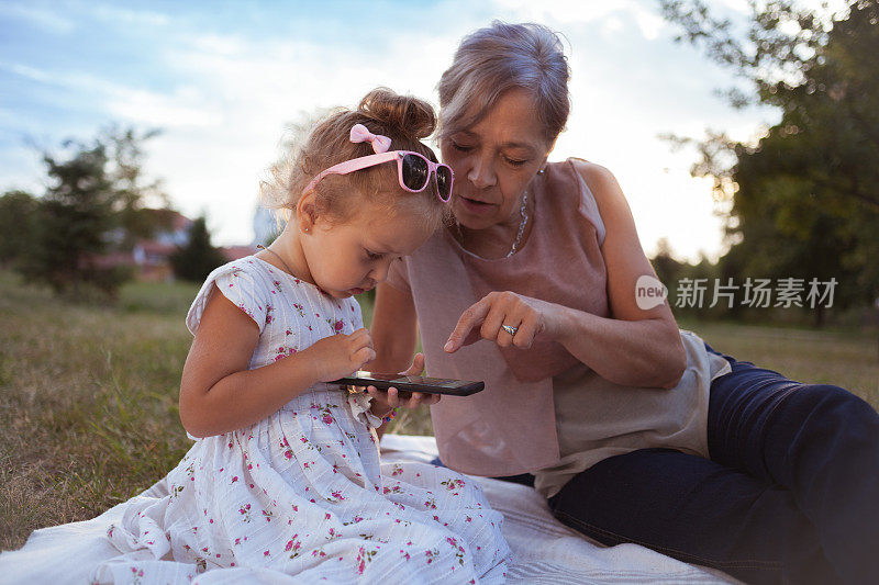 外婆和孙女在大自然中使用药片