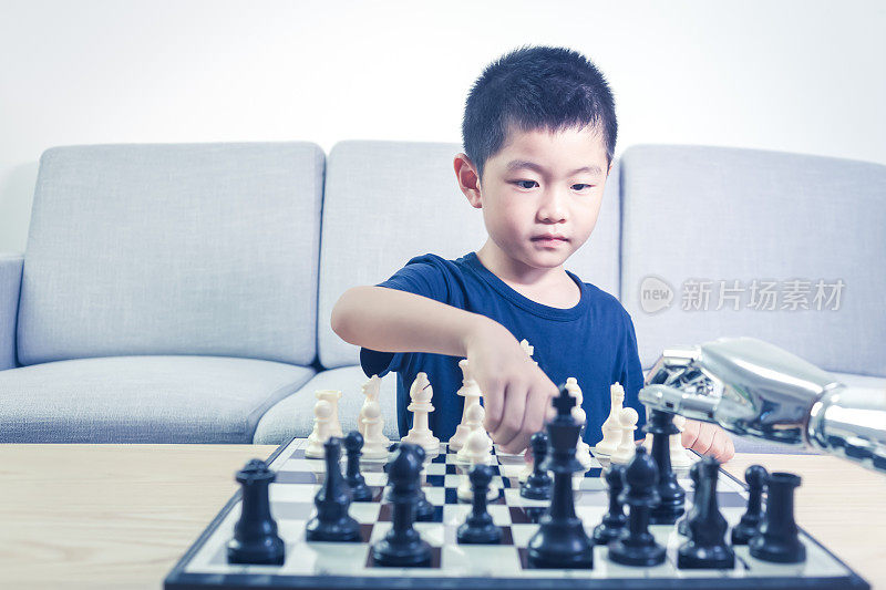聪明的男孩在室内与机器人下棋