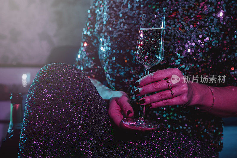 女人在新年派对上喝香槟起泡酒的特写