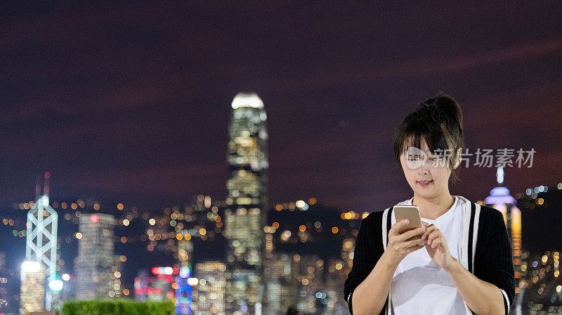 晚上在城里玩智能手机的女人