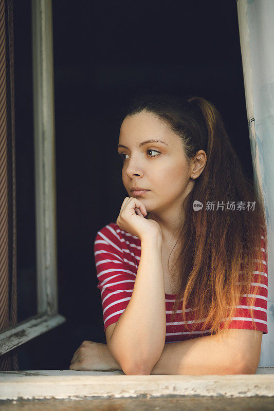 年轻女子正透过窗户往里看