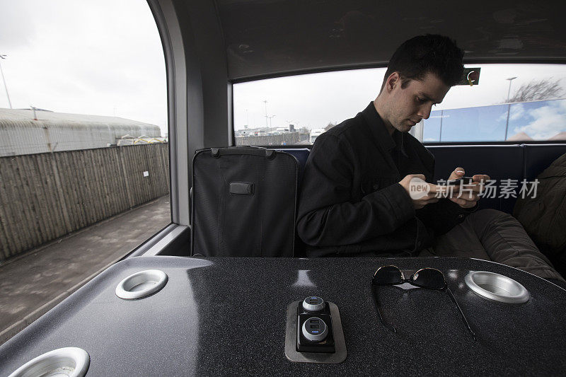 英国一名年轻人在穿梭巴士上使用手机