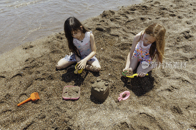 两个孩子在沙滩上玩耍