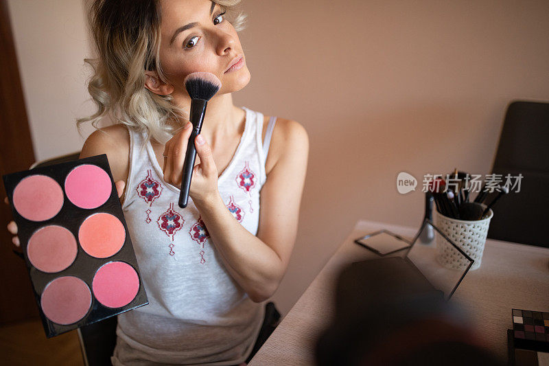 美丽的年轻女子关于化妆品的视频博客
