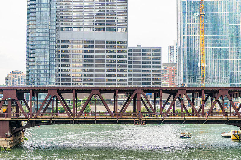一位身着鲜红色连衣裙的女士穿过芝加哥市中心标志性的红桥之一