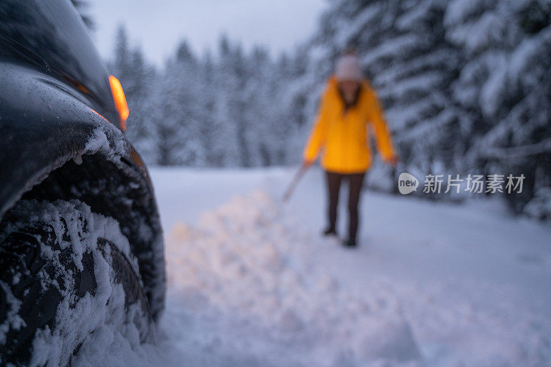 第一场雪后打扫汽车和扫地。紧急照明设备。在恶劣的天气下，汽车会在偏僻的地方抛锚。汽车保险。一个女人在路上。