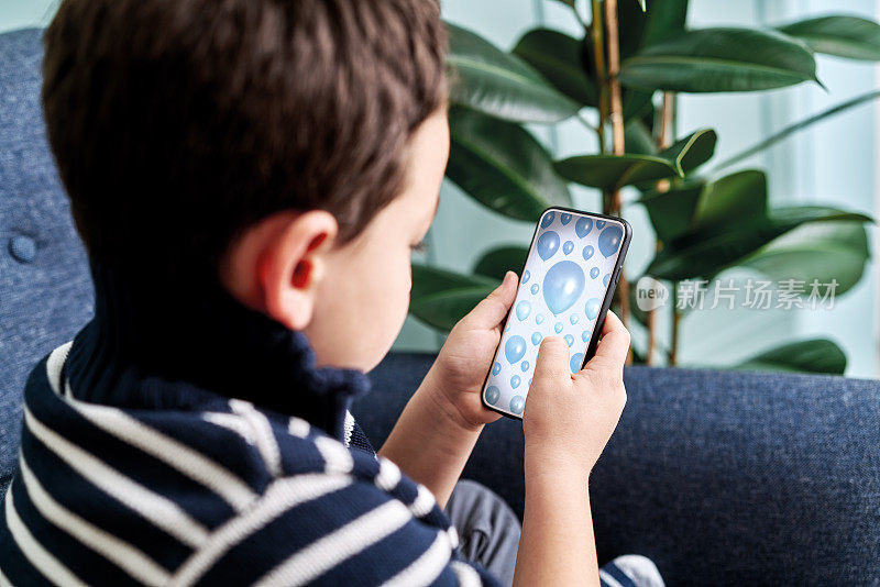 6-7岁儿童抱着并触摸智能手机。智能手机屏幕与剪切路径。