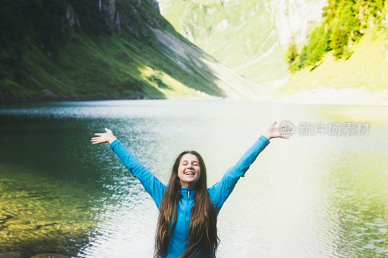 一名年轻女子在瑞士阿尔卑斯山的山湖上享受着夏日阳光明媚的早晨
