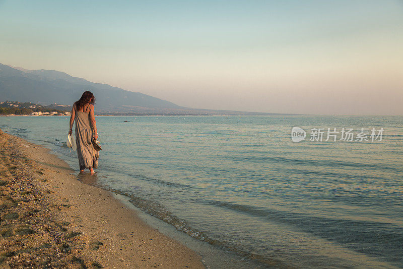 年轻女子喜欢早晨在海滩散步