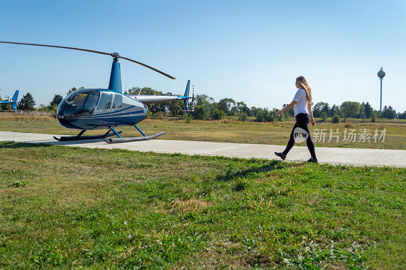 年轻的女飞行员走向停飞的直升机