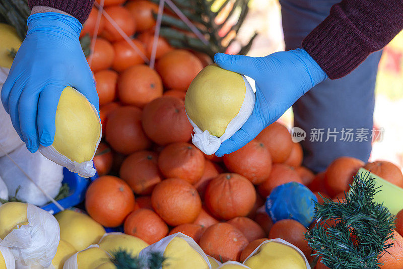 戴着橡胶手套的蔬菜水果商。