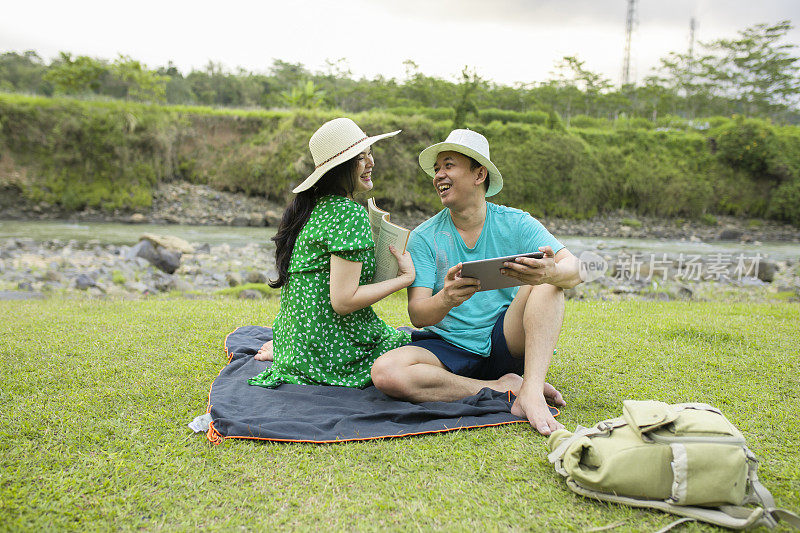 亚洲孕妇在农村旅行时，她的丈夫在网上工作