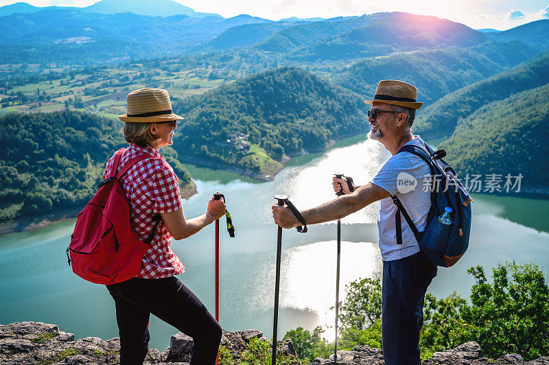 徒步旅行者站在山顶欣赏风景