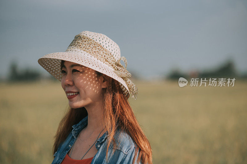 肖像亚洲微笑女性与草帽花闲暇时间在稻田