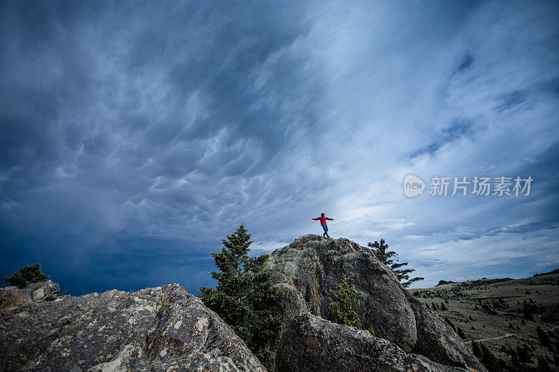 暴风雨前一个人在山脊上徒步旅行