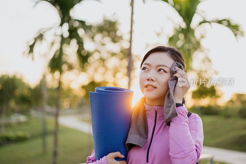 年轻的亚洲女性运动后擦拭汗水