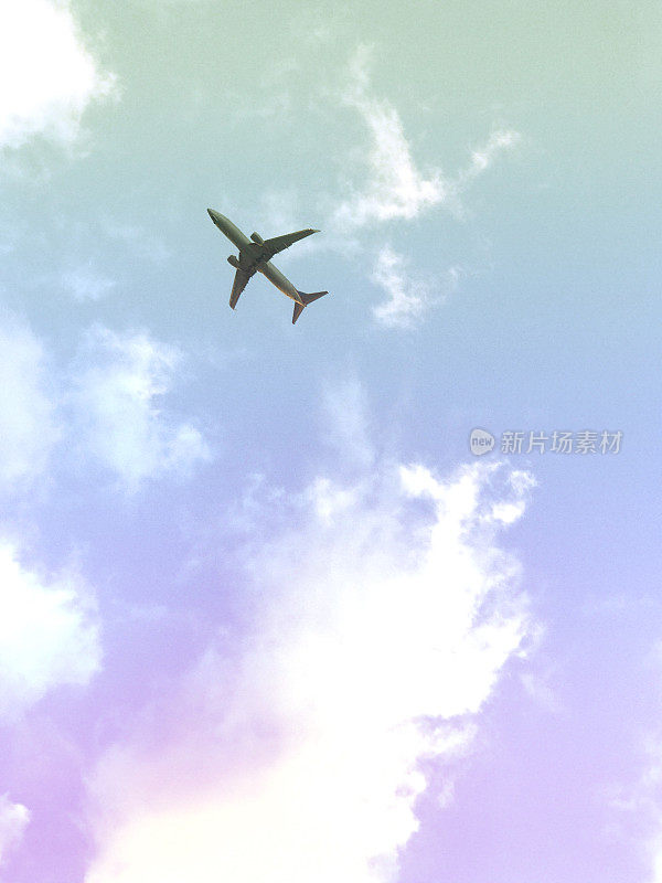 风景与白色的客机是飞过一个彩色的日落天空与彩云。