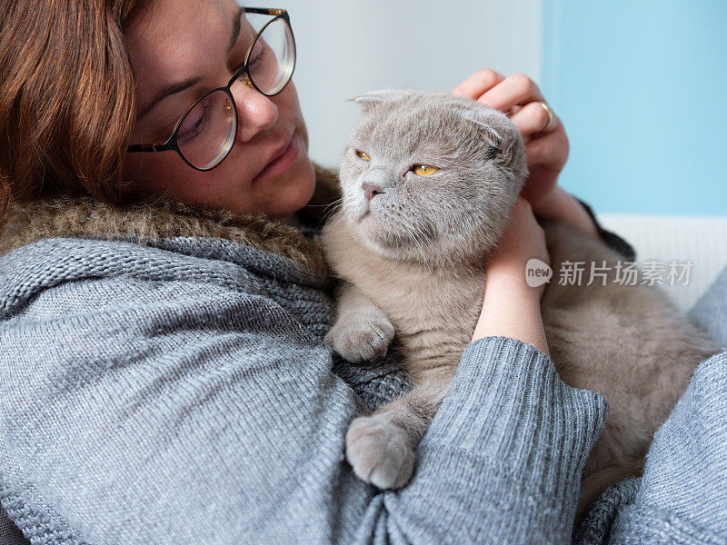 女人和猫在家里的沙发上休息