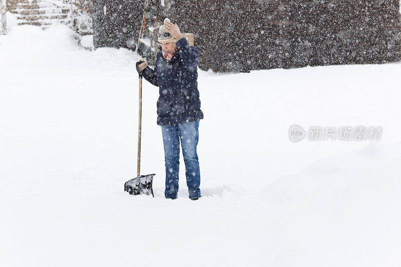 绝望的女人在铲雪