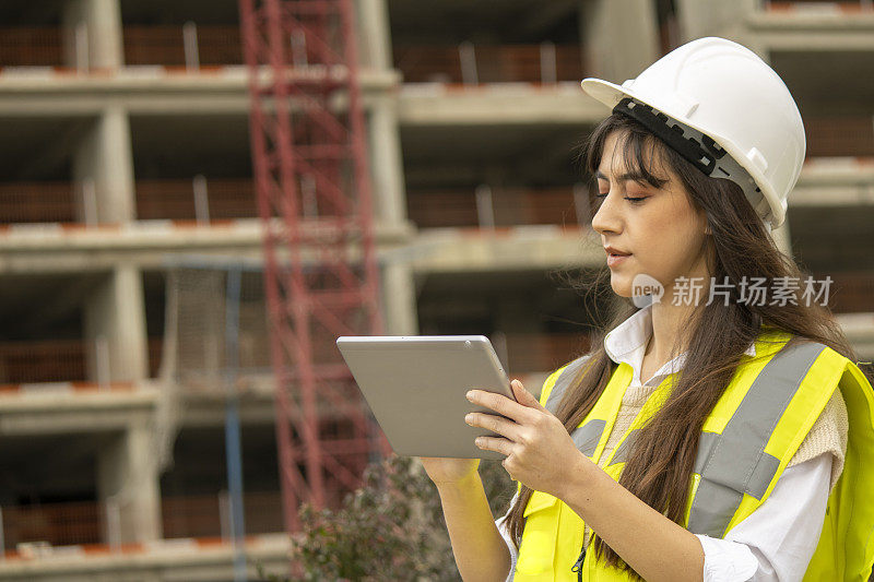 女建筑师在建筑工地与数字平板电脑