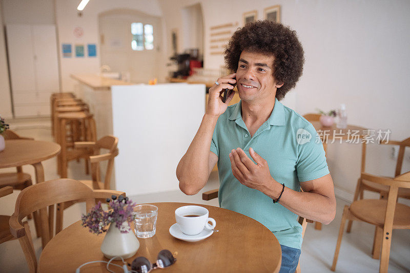非裔美国混血男子在咖啡馆使用智能手机