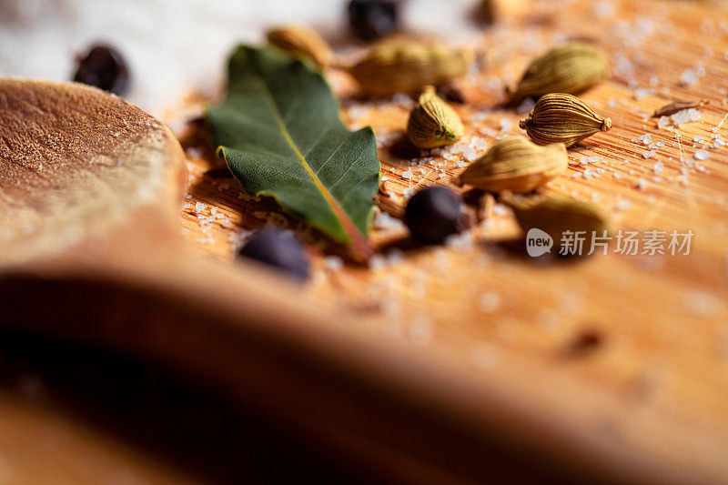 宏观的静物与腌渍盐和香料如葛缕子，小豆蔻，杜松子，月桂叶和木制厨房勺子和复制空间的底部