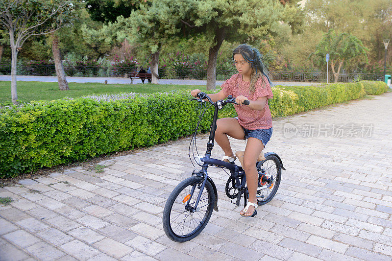 一个患有唐氏综合症的小女孩骑着自行车