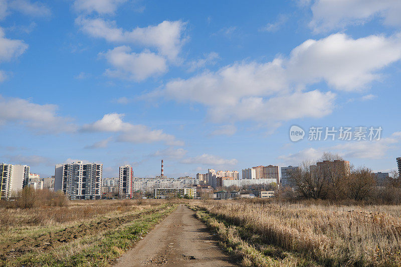 通往城市的道路穿过秋天的田野