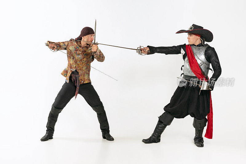 两名男子的全身肖像，在古老的服装，火枪手和海盗战斗与剑孤立在白色的背景