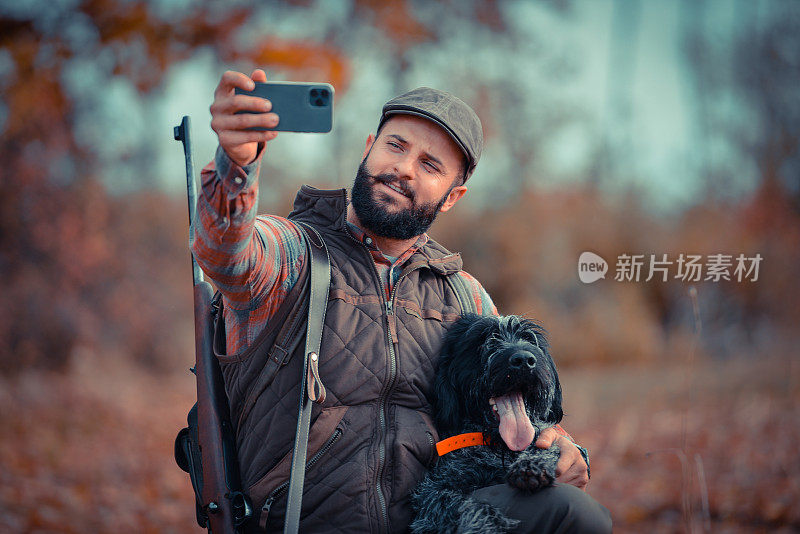年轻的猎人与他的德国长毛狗在大自然中自拍