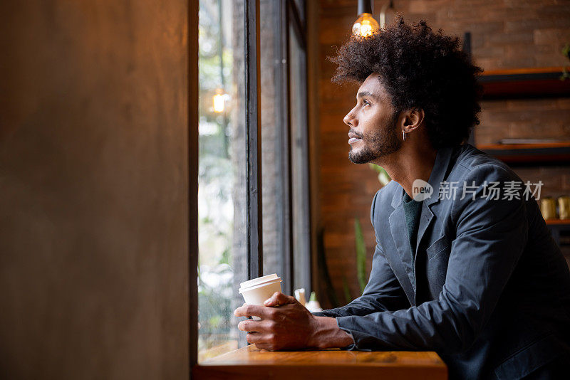 一位沉思的男士在咖啡馆喝着咖啡