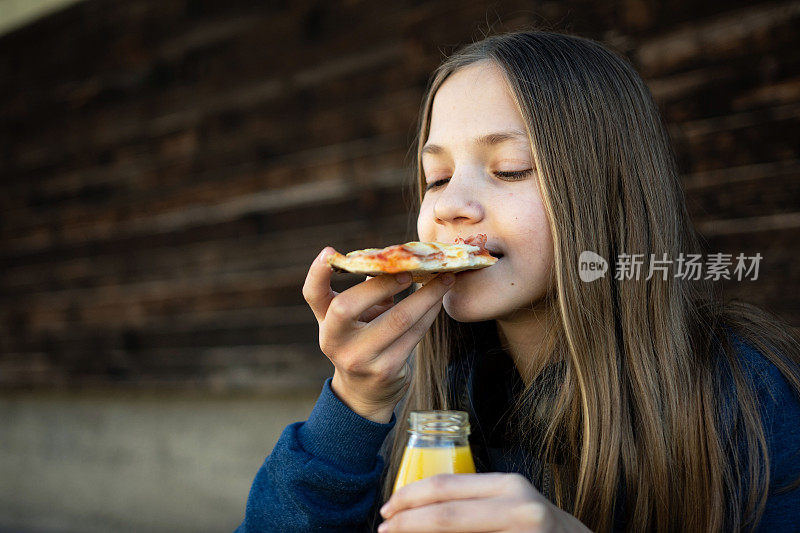 十几岁的女孩在户外吃披萨