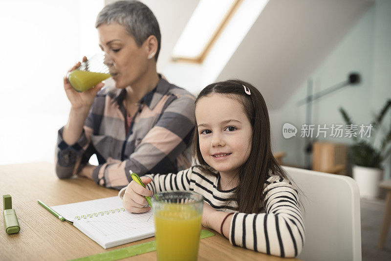 一个可爱的女孩和她妈妈做作业的肖像