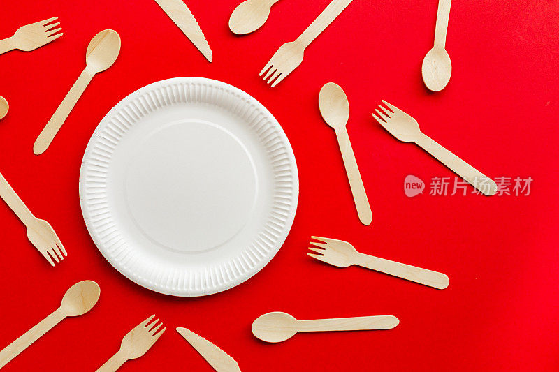 环保可回收的木制餐具和红色背景的纸盘