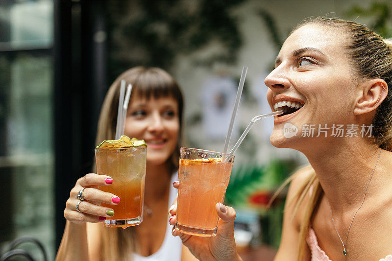 两个年轻女子在一起喝鸡尾酒