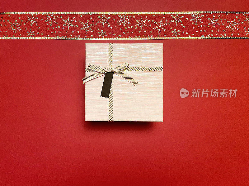 圣诞礼盒与华丽的丝带在红色的背景