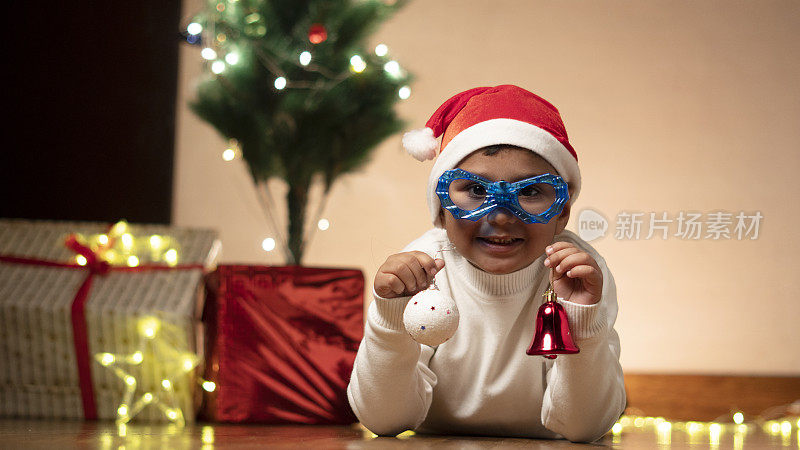 快乐的印度男孩戴着圣诞帽，滑稽的护目镜
