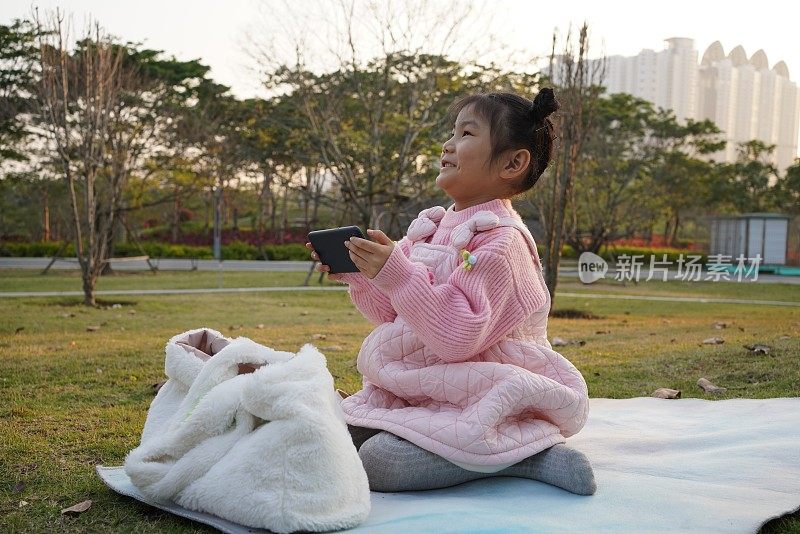 快乐的亚洲小女孩用手机看视频