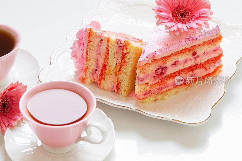 两杯茶，白色的桌子上放着粉红色的蛋糕