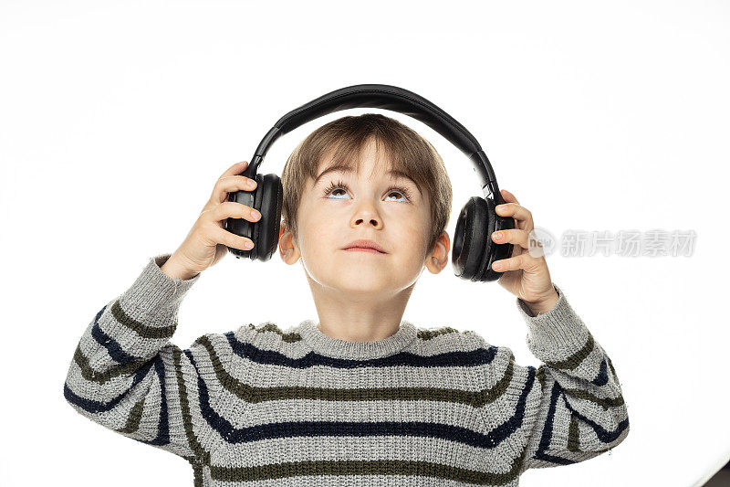 一个可爱的小男孩喜欢用无线耳机听音乐